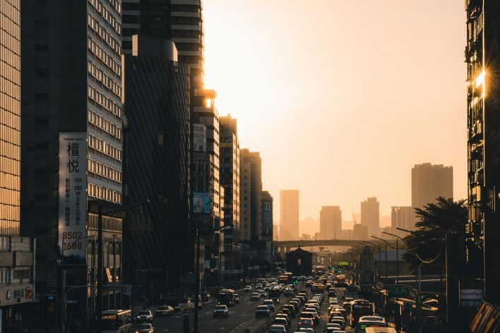 Dynamic cityscape shot during sunset showcasing busy streets and towering skyscrapers.
